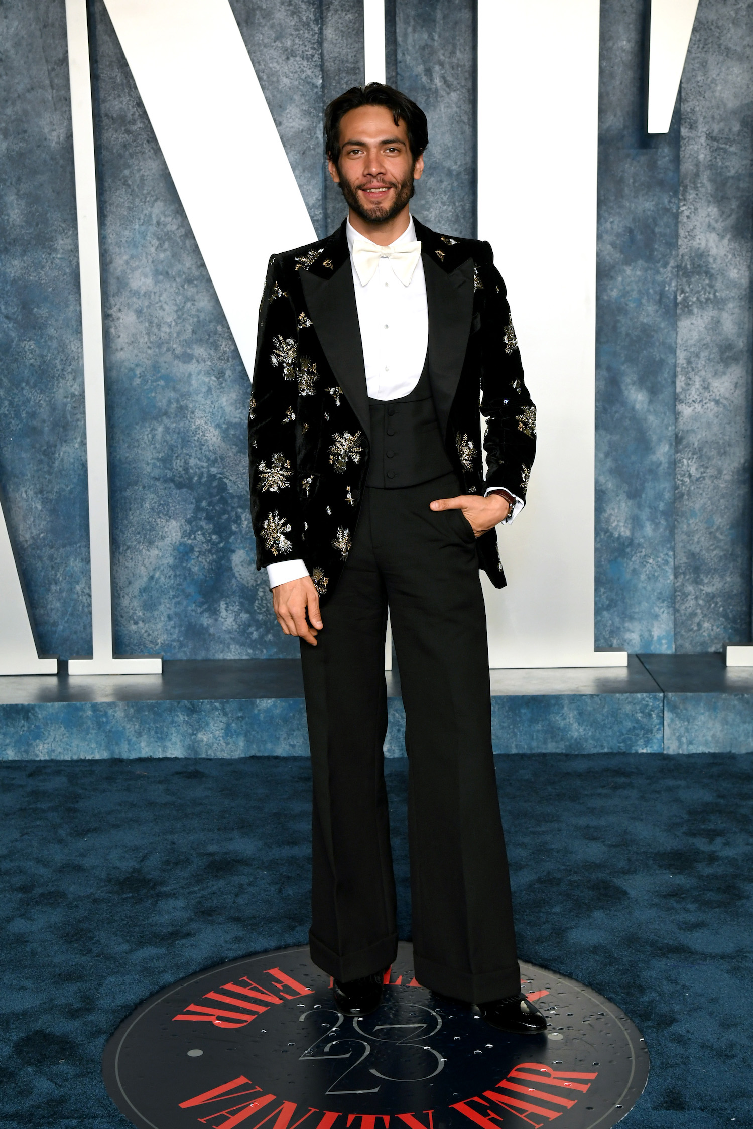Diego Calva wore a black Gucci velvet embroidered tuxedo, white evening shirt, ivory bowtie, and black patent leather loafers.
