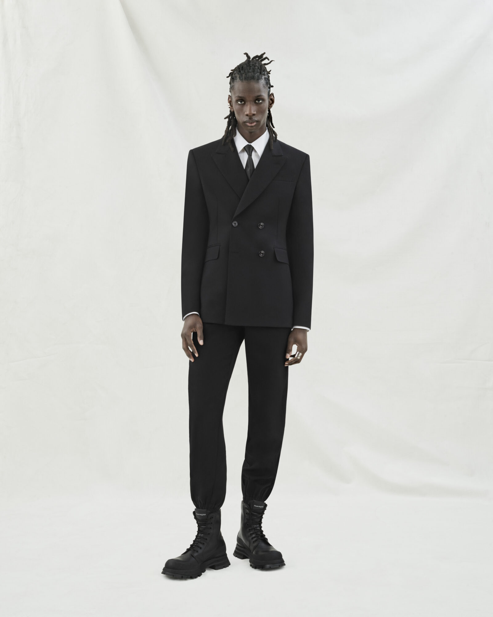 Look 01: Double-breasted jacket and cargo trousers in rich black wool gabardine.