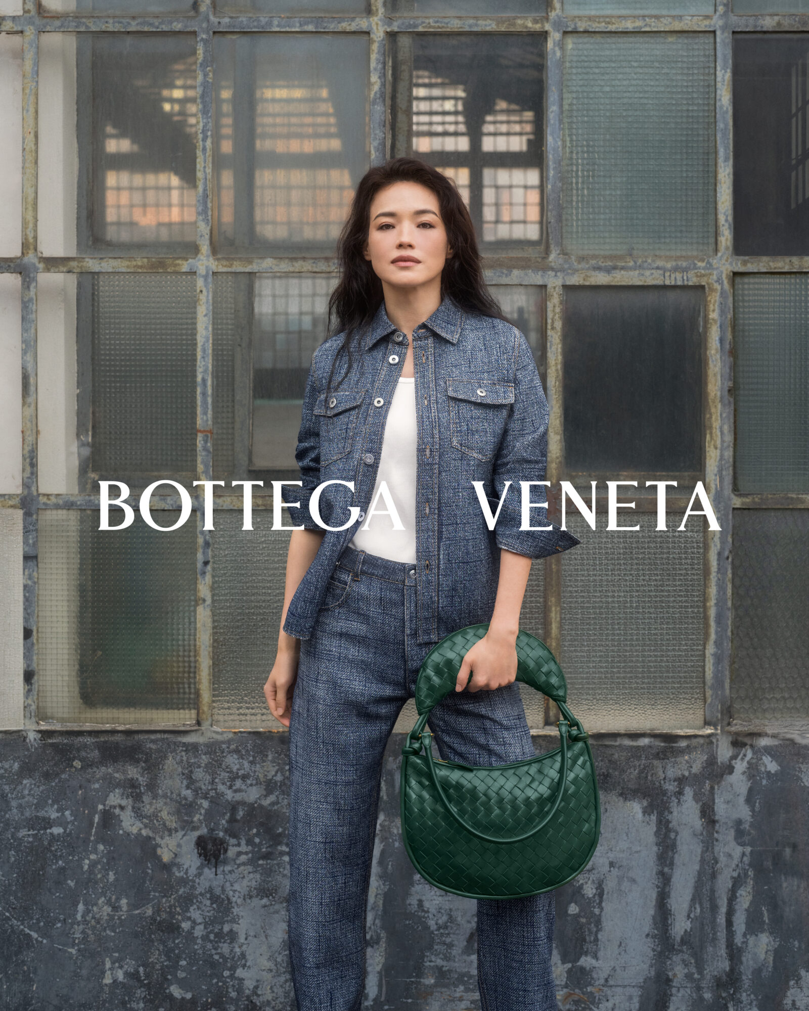 Pairing denim-on-denim with Bottega Veneta's iconic Gemelli woven leather handbag, Shu Qi redefines urban chic for the brand's latest campaign.