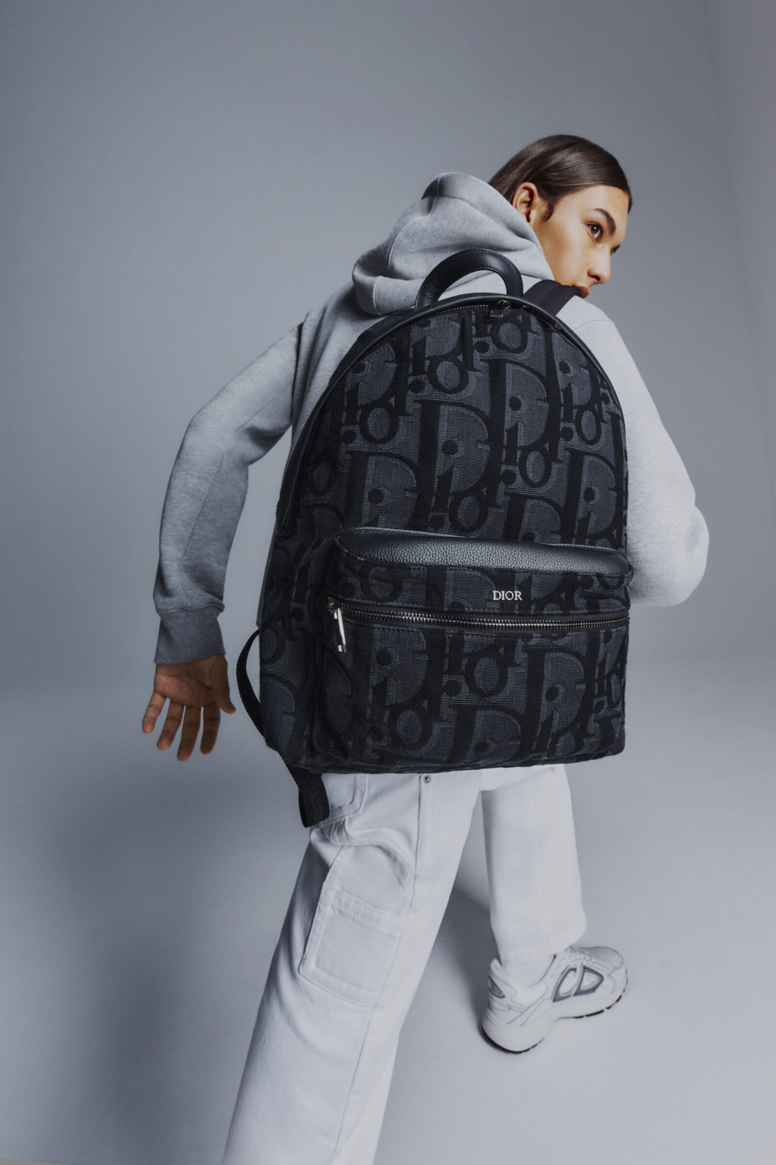 A sleek and modern Maxi DIOR Oblique monogrammed backpack elegantly worn, exemplifying urban sophistication.