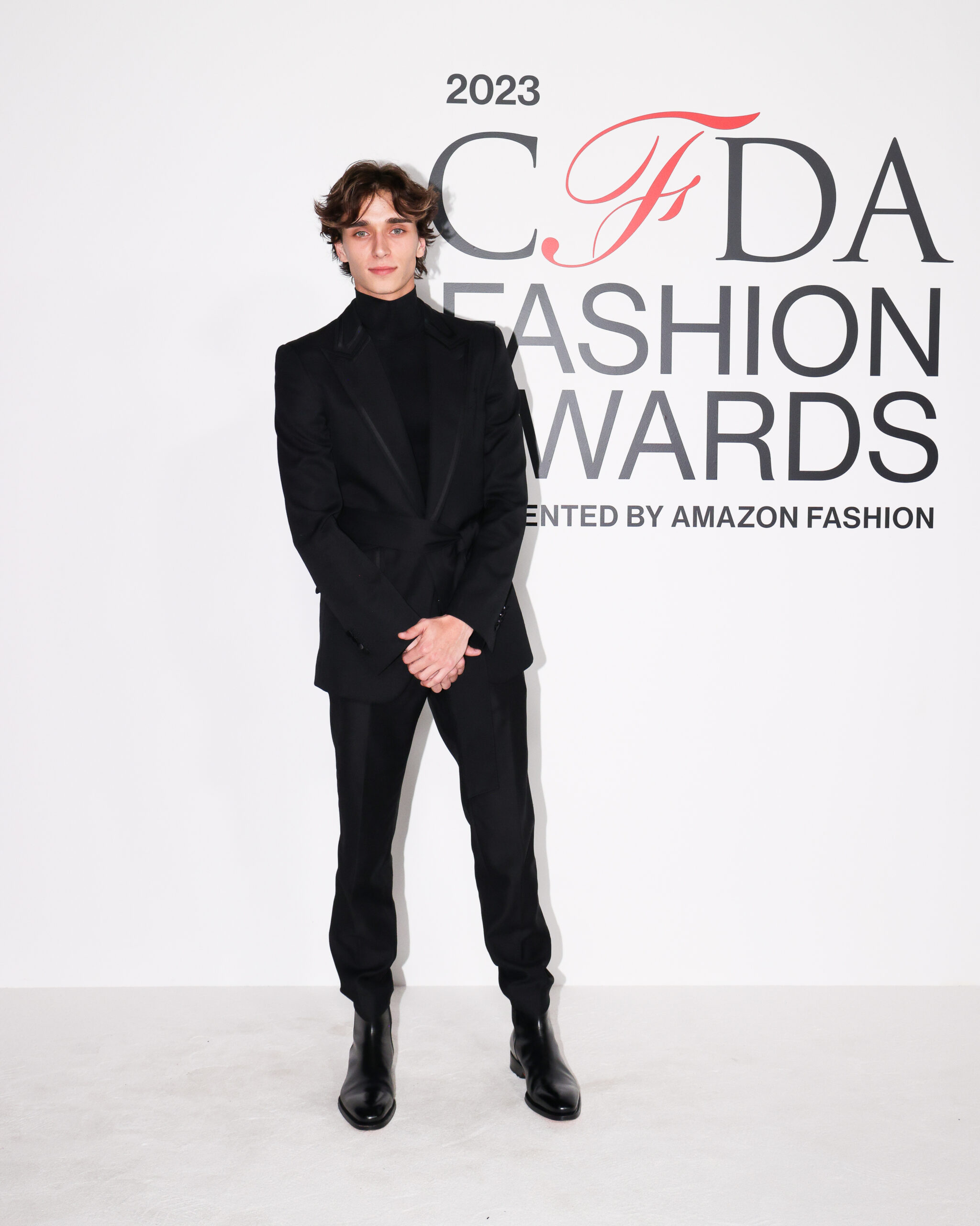 Josh Richards exudes effortless style at the 2023 CFDA Awards in a sleek black Dolce &amp; Gabbana suit with satin detailing, paired with heeled Chelsea boots.