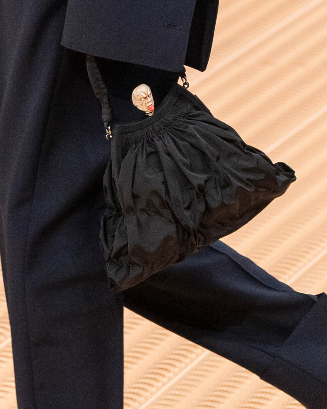 The Mario Prada handbag is presented alongside a minimalist Prada outfit, encapsulating the brand’s ethos of powerful understatement.
