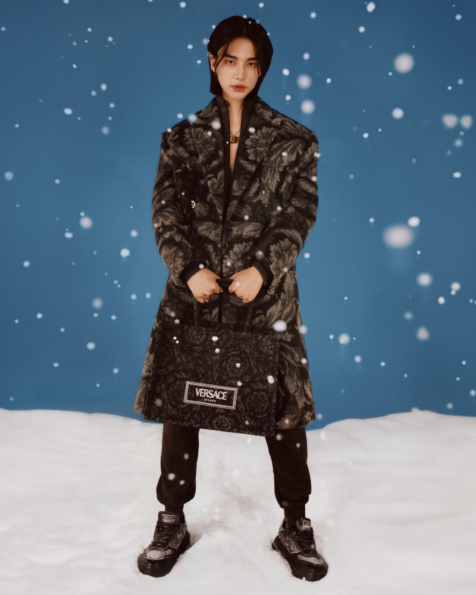 Winter wonder: Hyunjin wraps up in a Versace Barocco-print coat, ready to take on the festive chill with style.