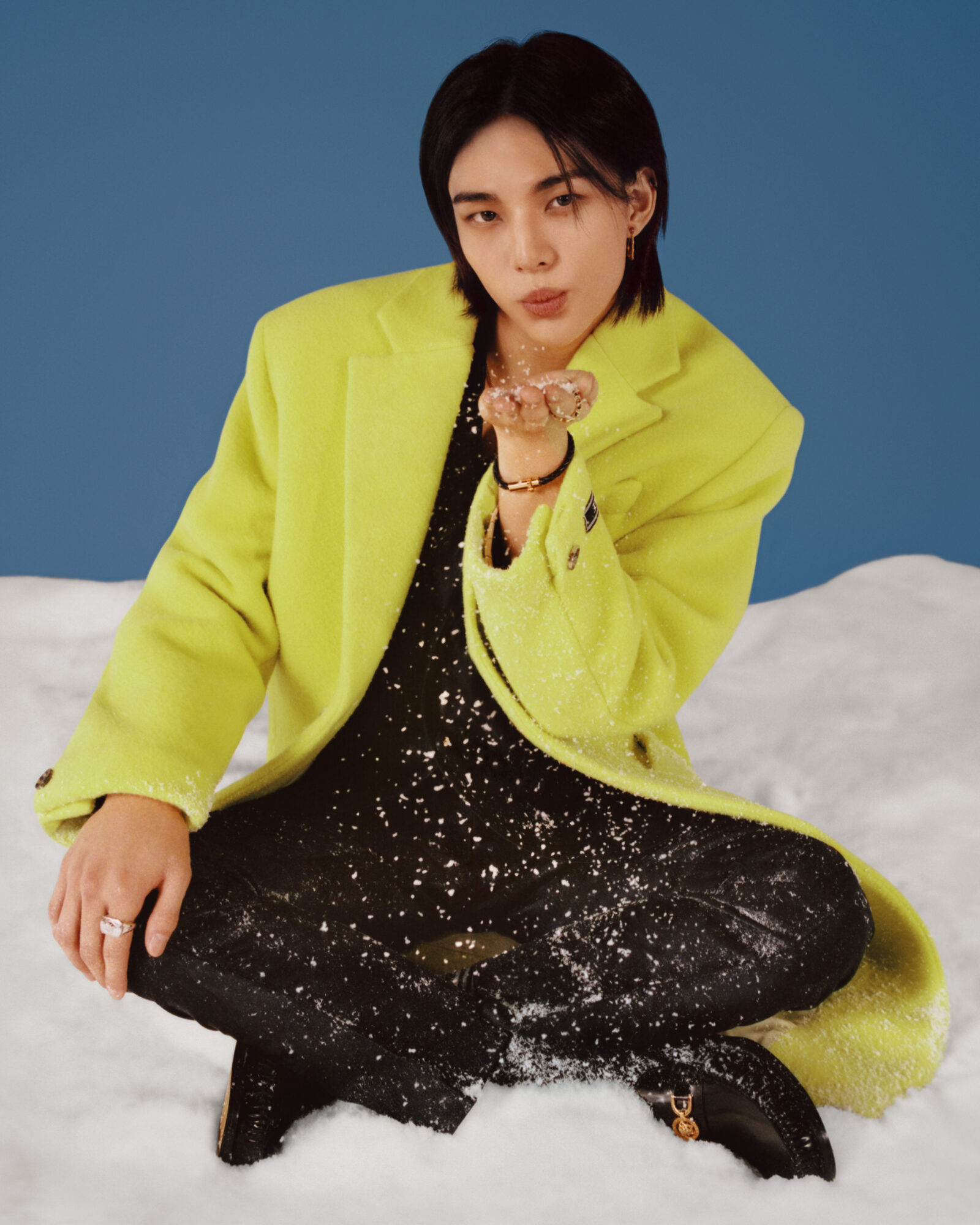 A splash of neon in the snow: Hyunjin dazzles in a vibrant Versace jacket, bringing warmth to the winter scene.