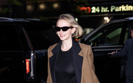 Carey Mulligan is seen walking in New York, styled in a Bottega Veneta wool coat and carrying the brand's woven leather bag, exuding classic style.