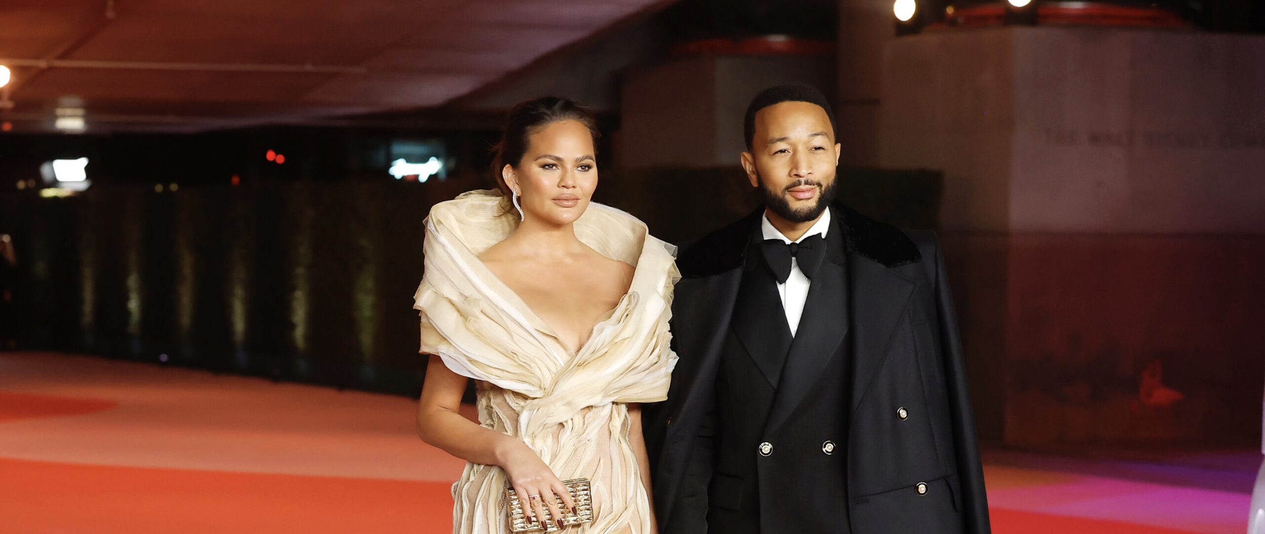 Chrissy Teigen in a stunning draped gown and John Legend in a classic black coat attend the Academy Museum of Motion Pictures Gala in Los Angeles.