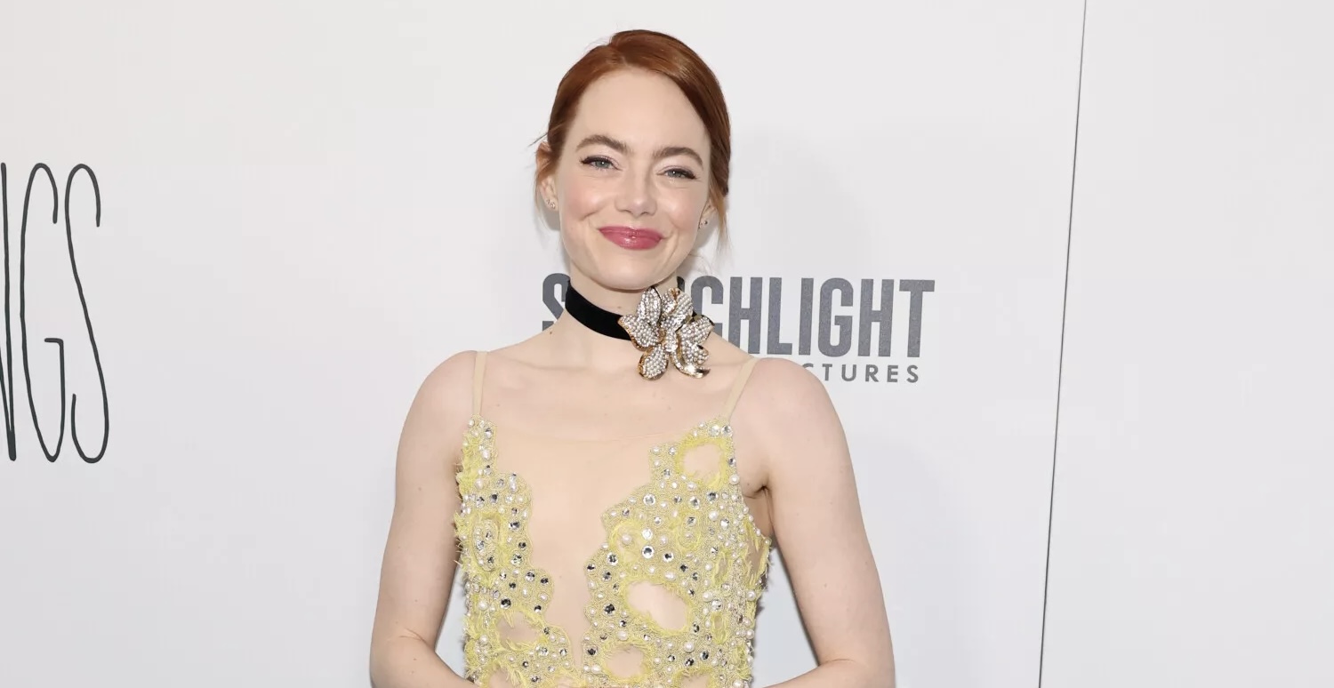 Emma Stone at the 'Poor Things' premiere in a bedazzled yellow Louis Vuitton gown, radiating elegance on the red carpet.