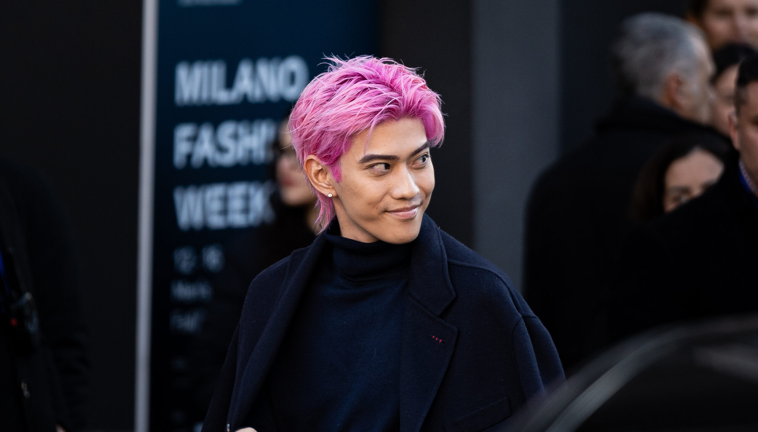 Yamato, with pink hair, arrives at the Gucci FW24-25 men's show during Milan Fashion Week, carrying a black handbag.