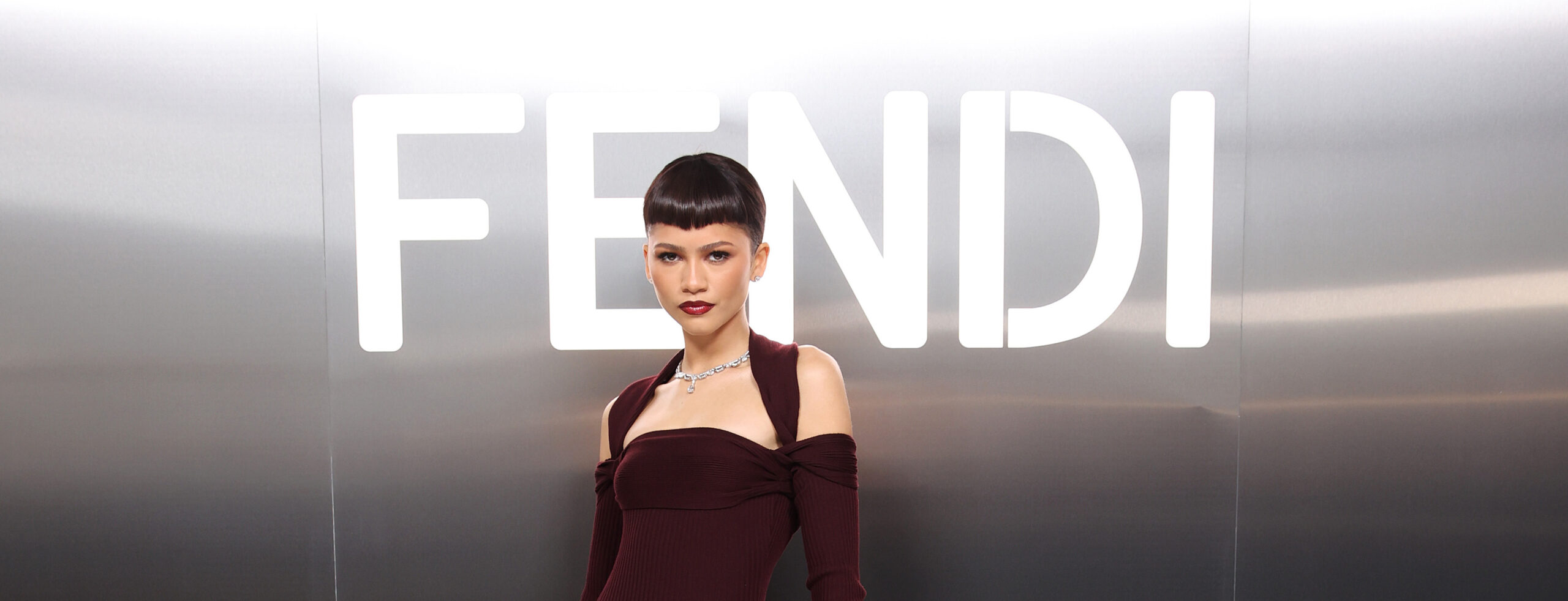Zendaya stands in front of a lit FENDI logo at FENDI Couture Spring 2024 in Paris.