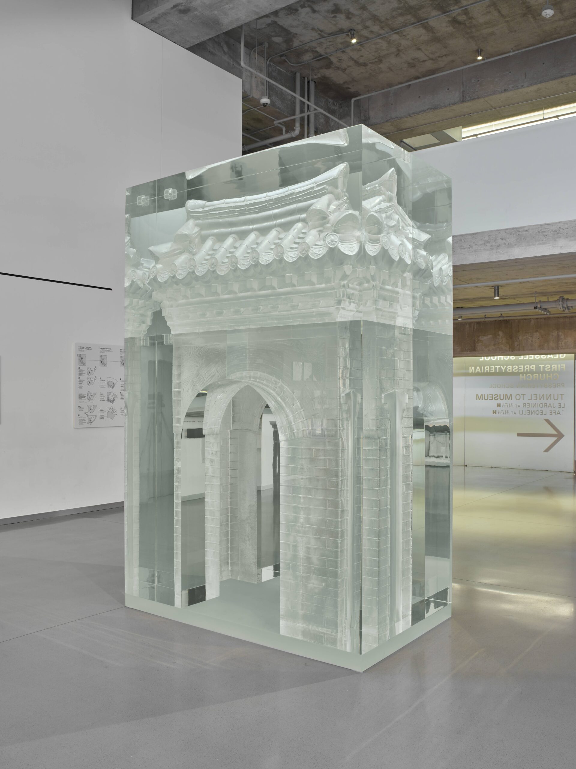An installation by artist Do Ho Suh, titled "Portal," is displayed at the Museum of Fine Arts, Houston. The translucent sculpture, meticulously crafted to resemble an architectural gateway, stands tall with detailed carvings and a ghostly appearance, allowing viewers to see through its ethereal structure.