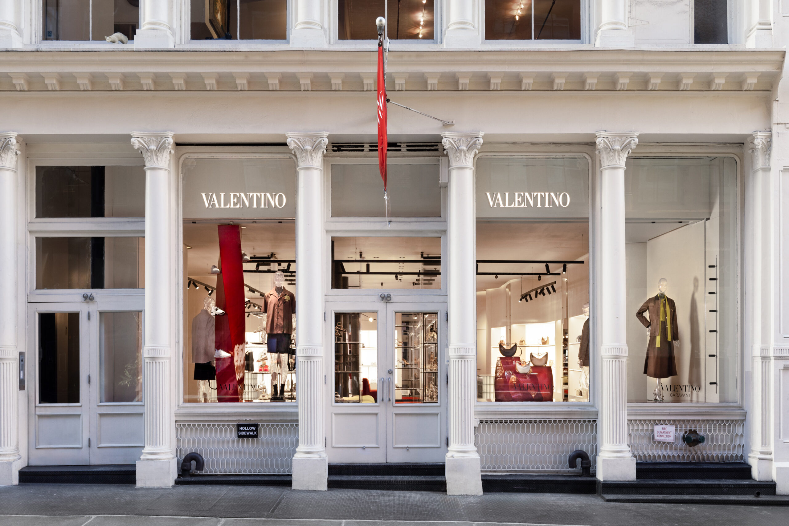 Exterior view of Valentino boutique at 98 Prince Street in New York's SoHo with large display windows showcasing fashion items.