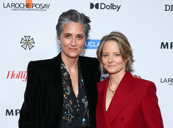 Jodie Foster, in a custom red Gucci suit, and Alexandra Hedison, in a black velvet ensemble with floral details, stand side by side at the MPTF's 22nd Annual Night Before event.