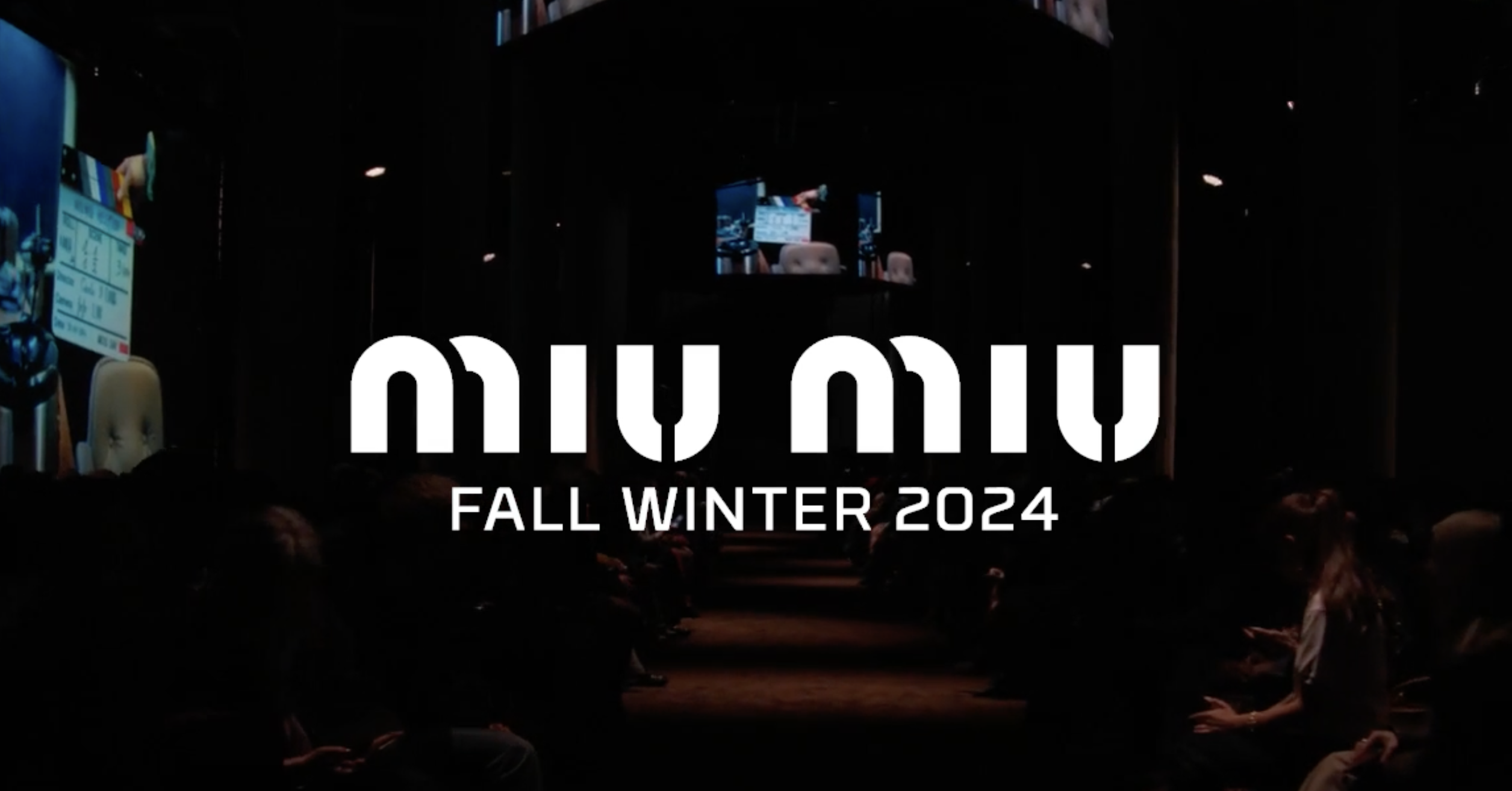 Promotional image for Miu Miu Fall/Winter 2024 fashion show, with the Miu Miu logo in white overlaying a dimly lit audience in a runway hall, hinting at the start of the event at Palais d'Iéna.