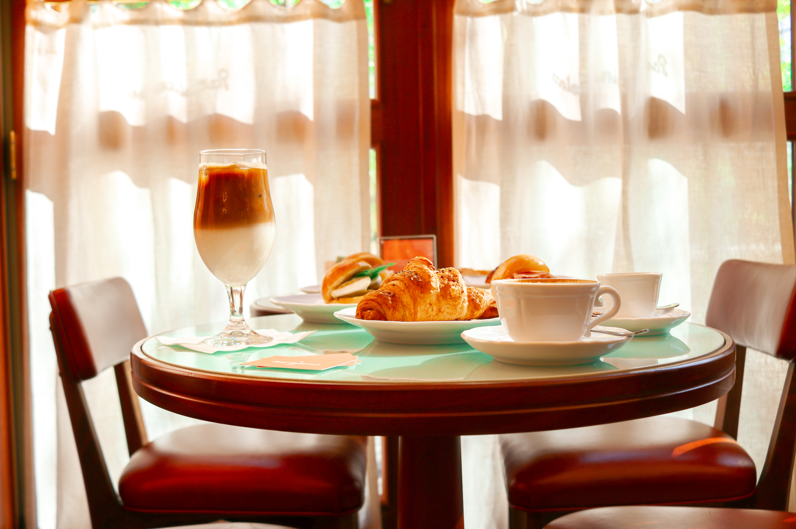 Morning light streams through Sant Ambroeus Aspen, where signature layered caffè freddo and house-made croissants await guests.